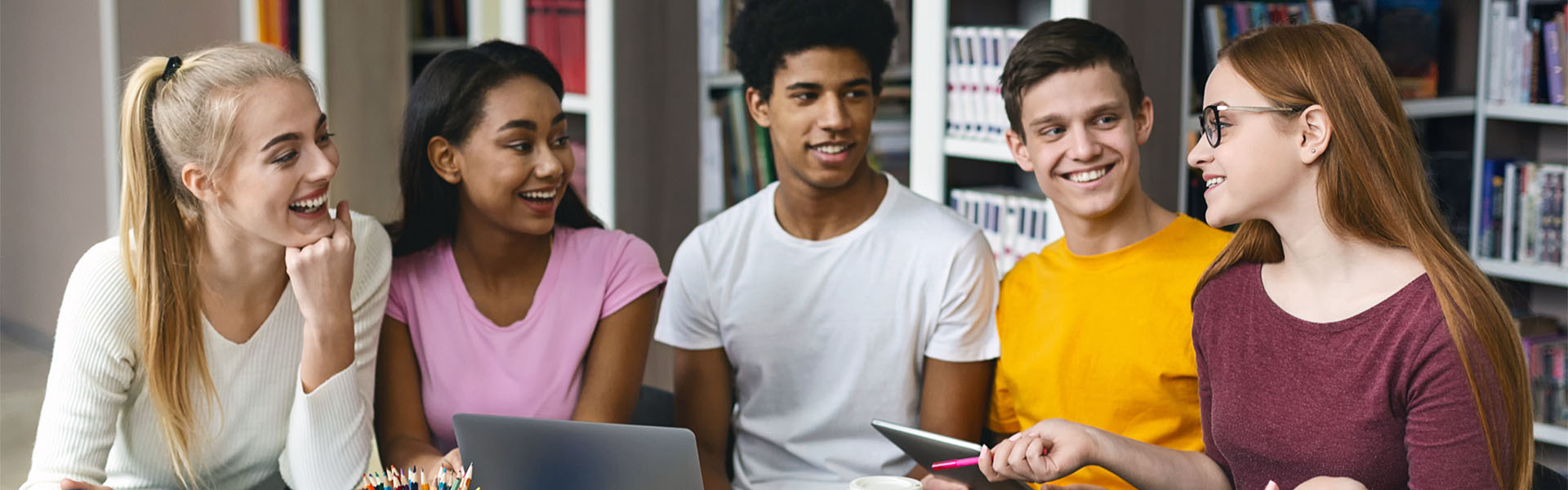 Young students huddled around table talking